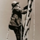 Fireman climbing ladder with gear and hose